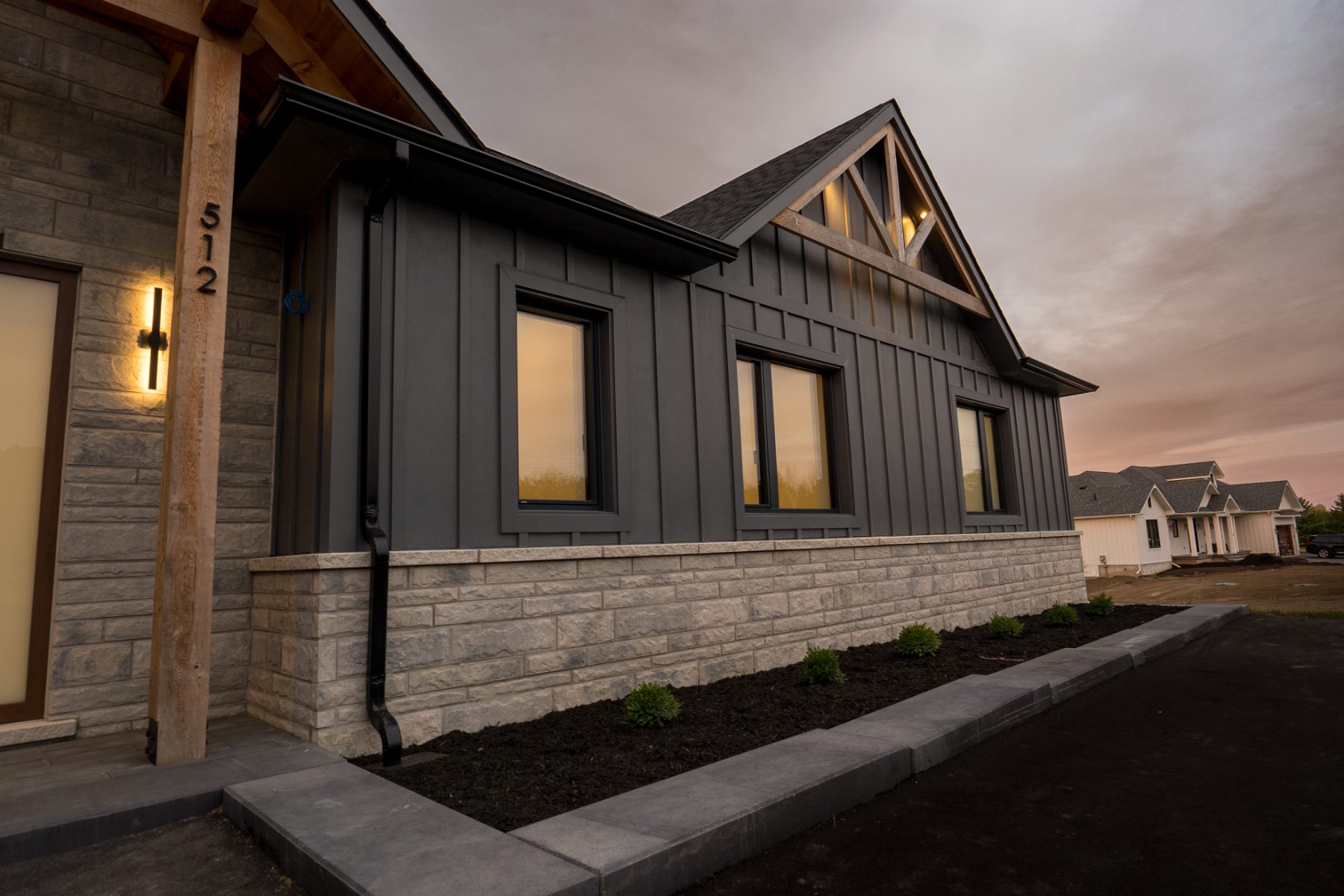 A MAE custom home: dark board-and-batten ranch at dusk